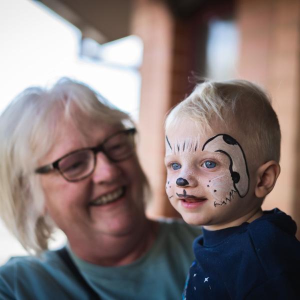 Women holding child with face painted