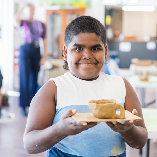 Workshop participant holding their clay creation 