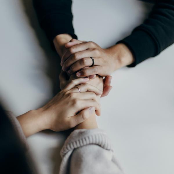 Hands holding eachother across a table