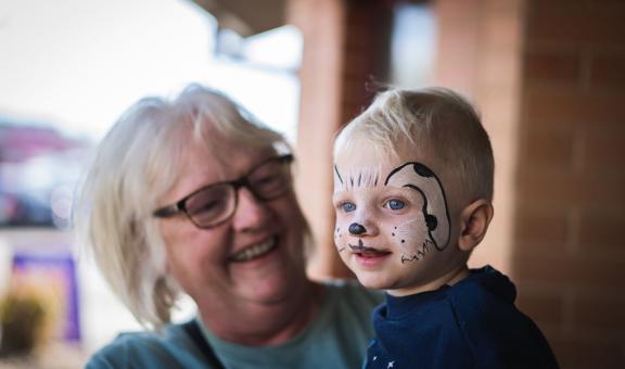 Women holding child with face painted