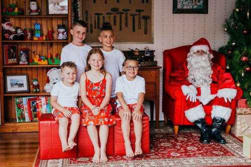 five children sitting with Santa for a Santa photo