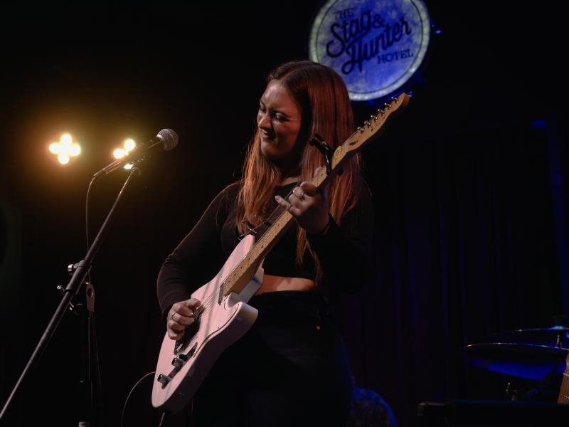 Piper Butcher playing guitar on stage