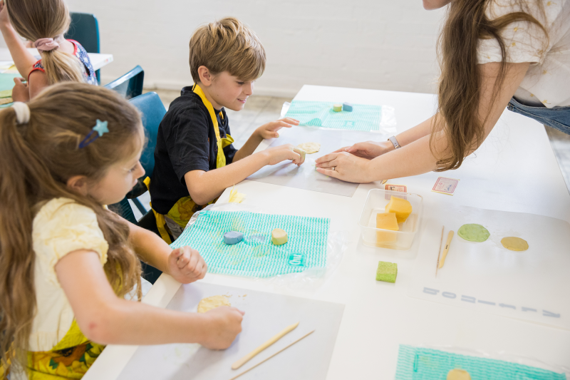 Children participating in a clay workshop