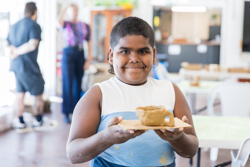 Workshop participant holding their clay creation 