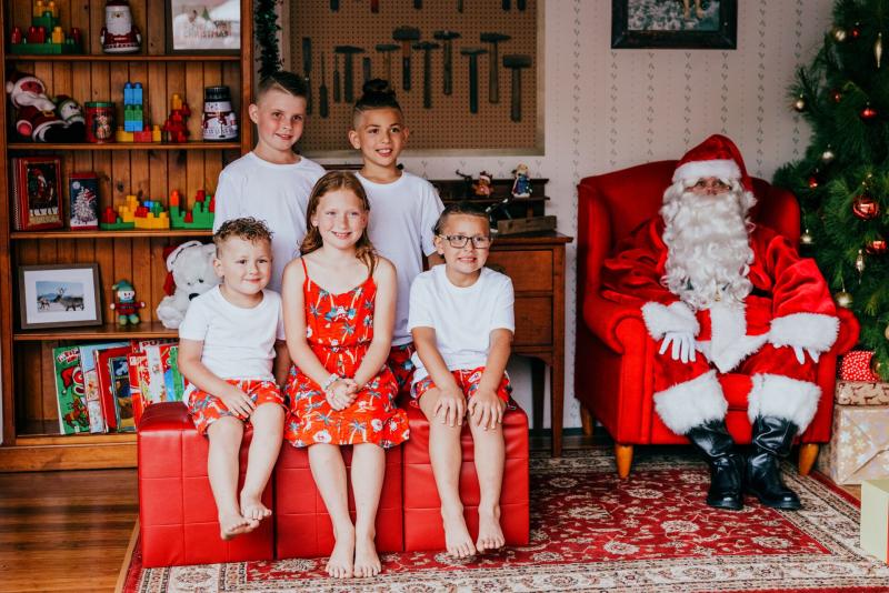 five children sitting with Santa for a Santa photo