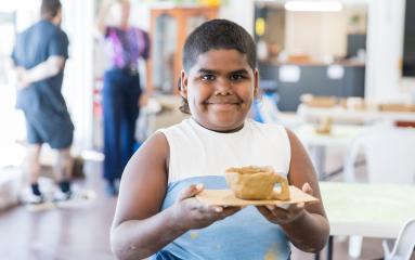 Workshop participant holding their clay creation 