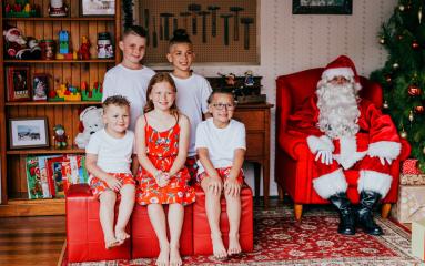 five children sitting with Santa for a Santa photo