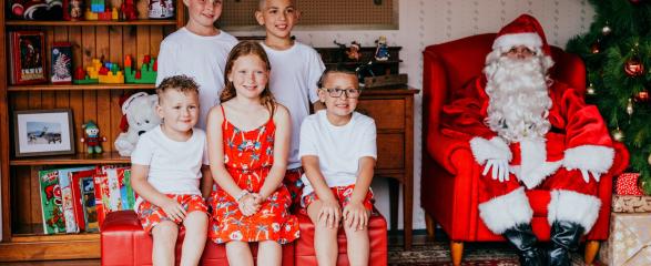 five children sitting with Santa for a Santa photo