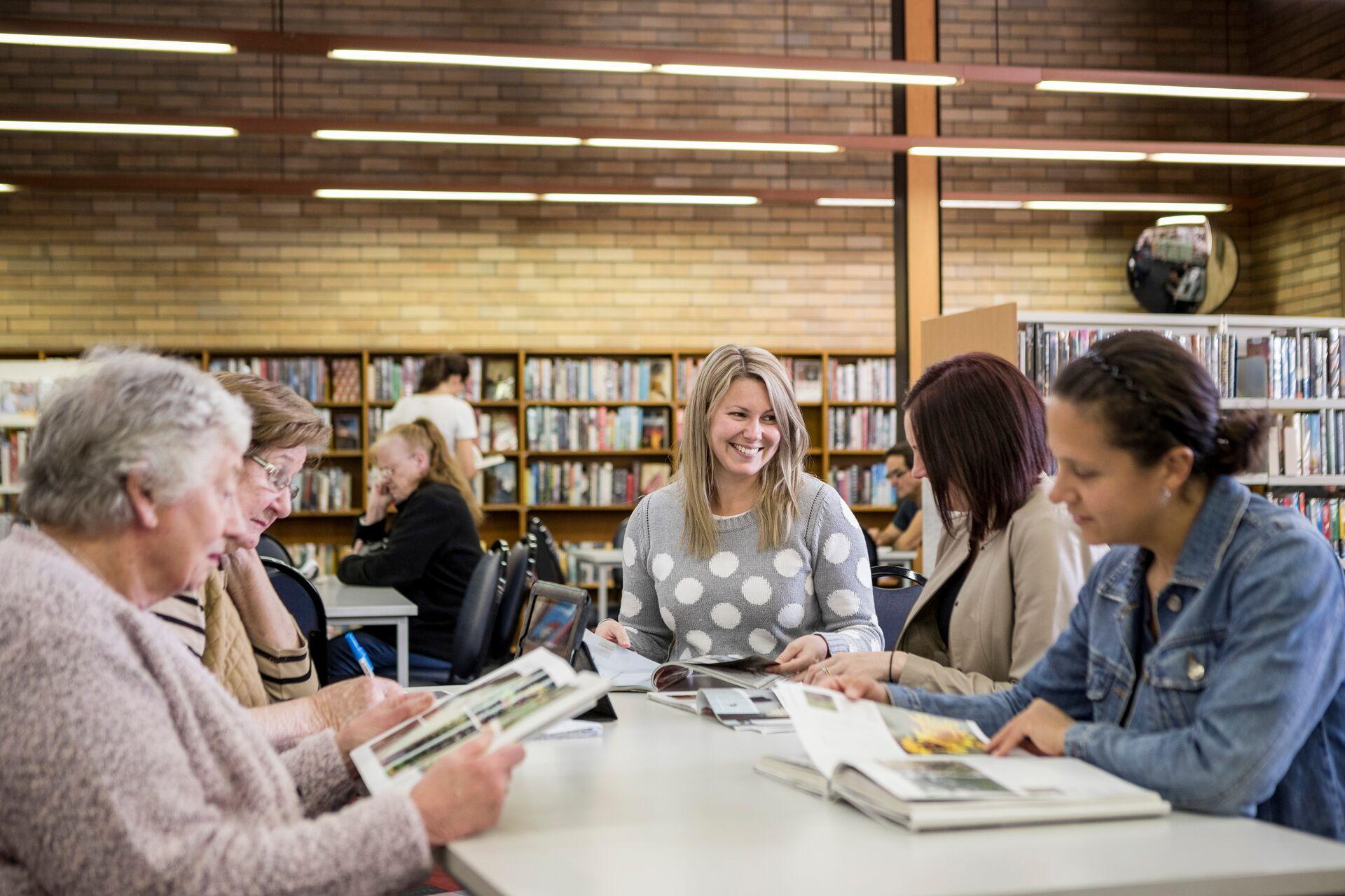 Group of woman sitting at table reading at Maitland library