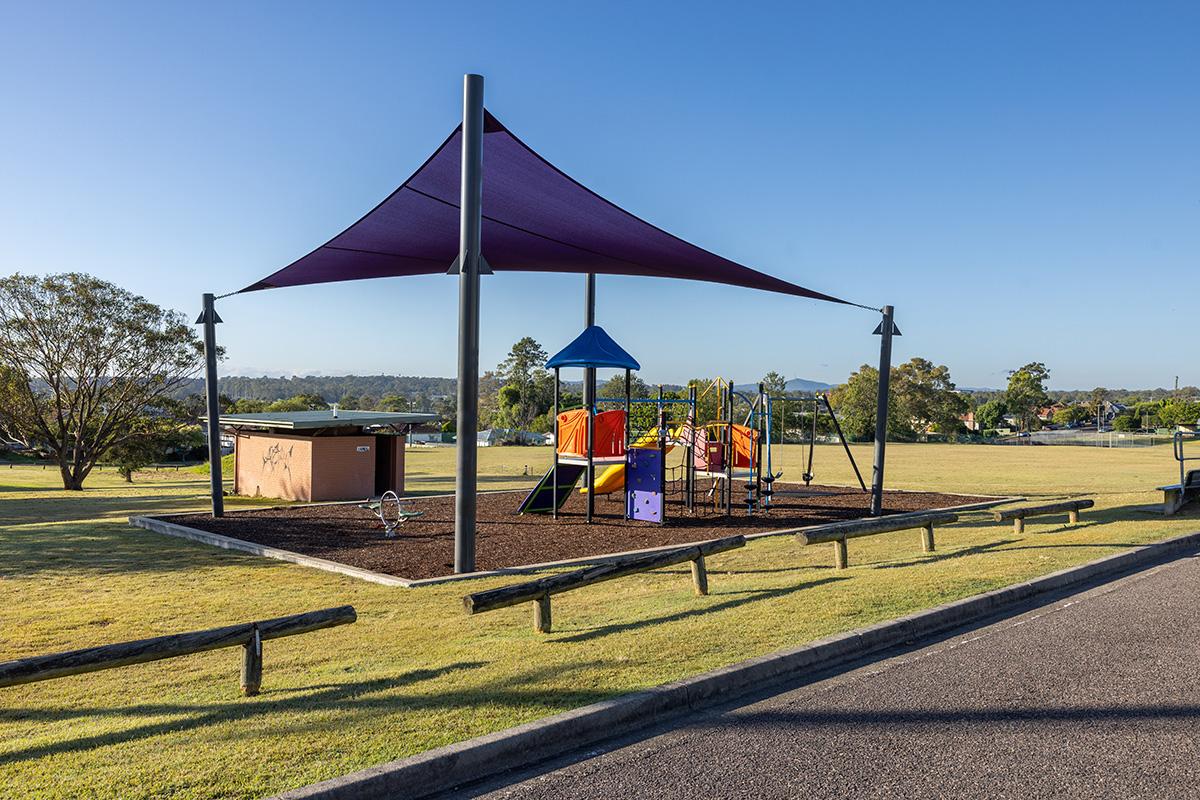 Playground under sun shade and amenities at centennial park, view from road 