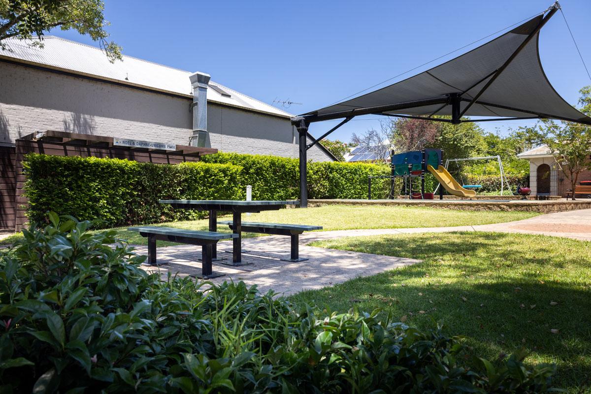 shade sail, playground and seating area