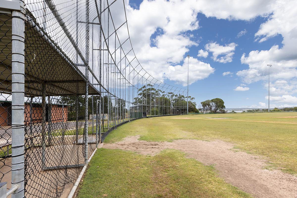 Protective sports fencing on perimeter of oval 