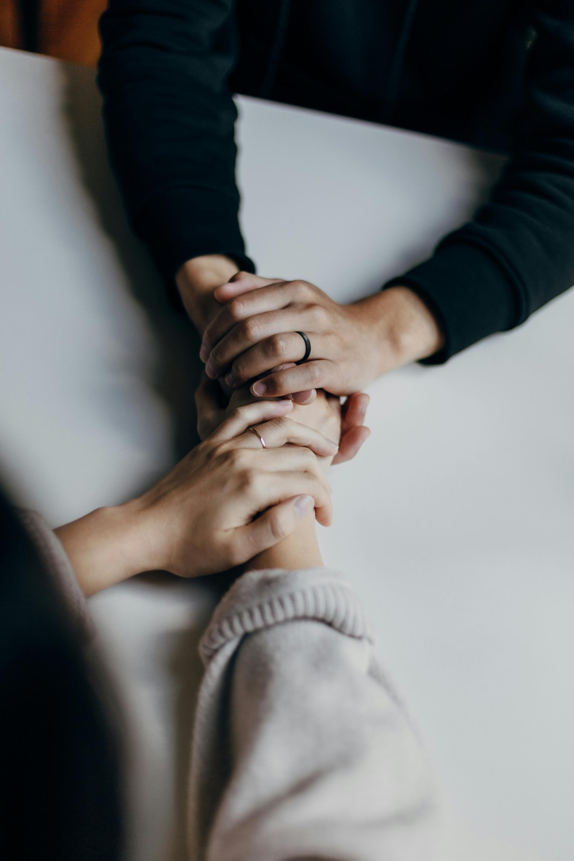 Hands holding eachother across a table