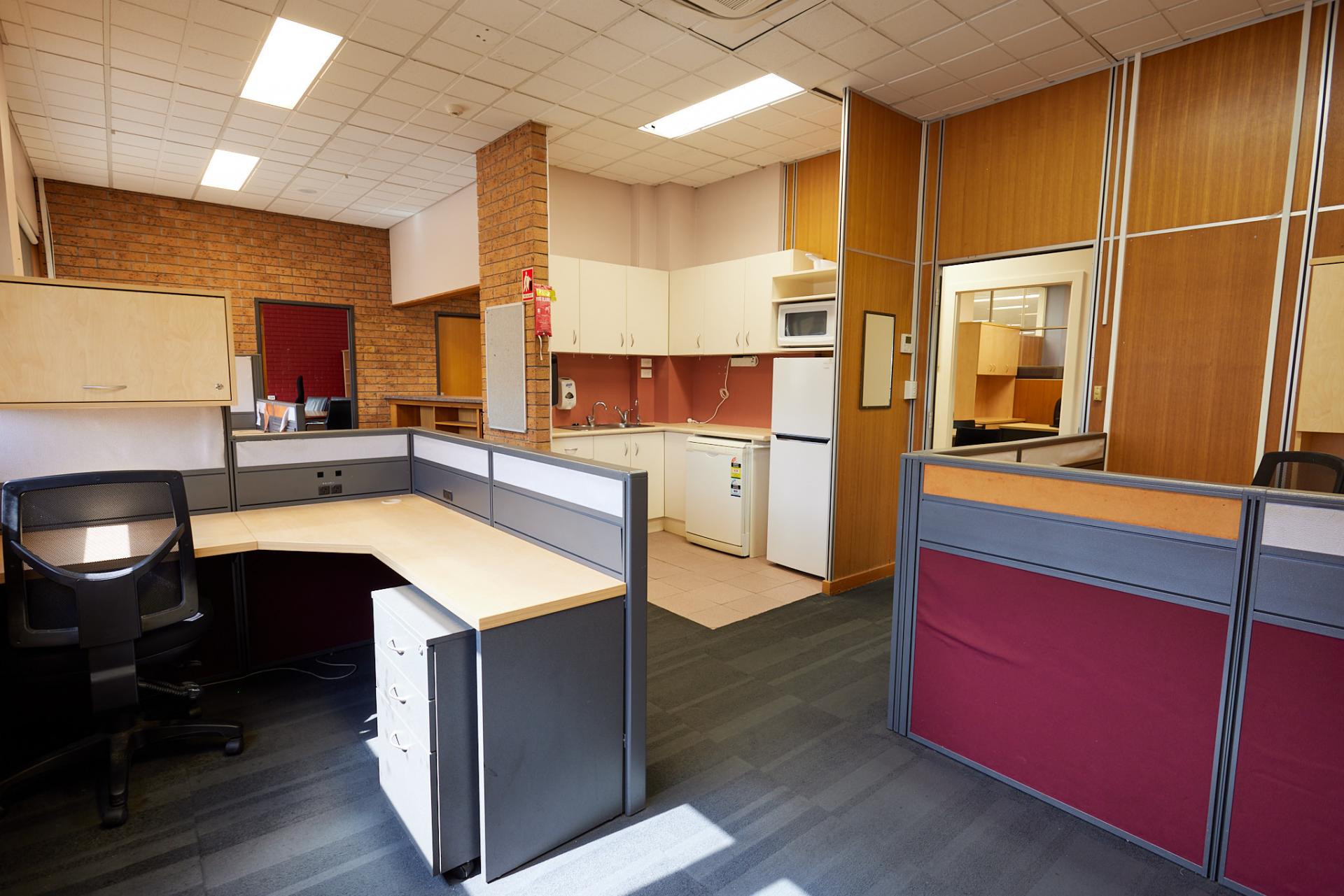 Several desks and working spaces with small kitchenette